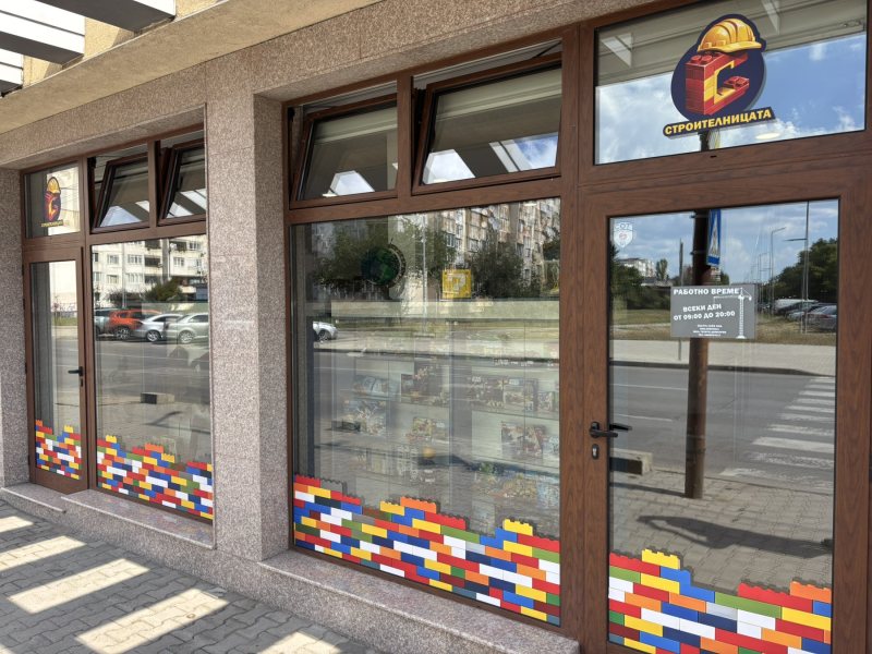 Витрината на Строителницата отвън, с лего тухлички по стъклото
